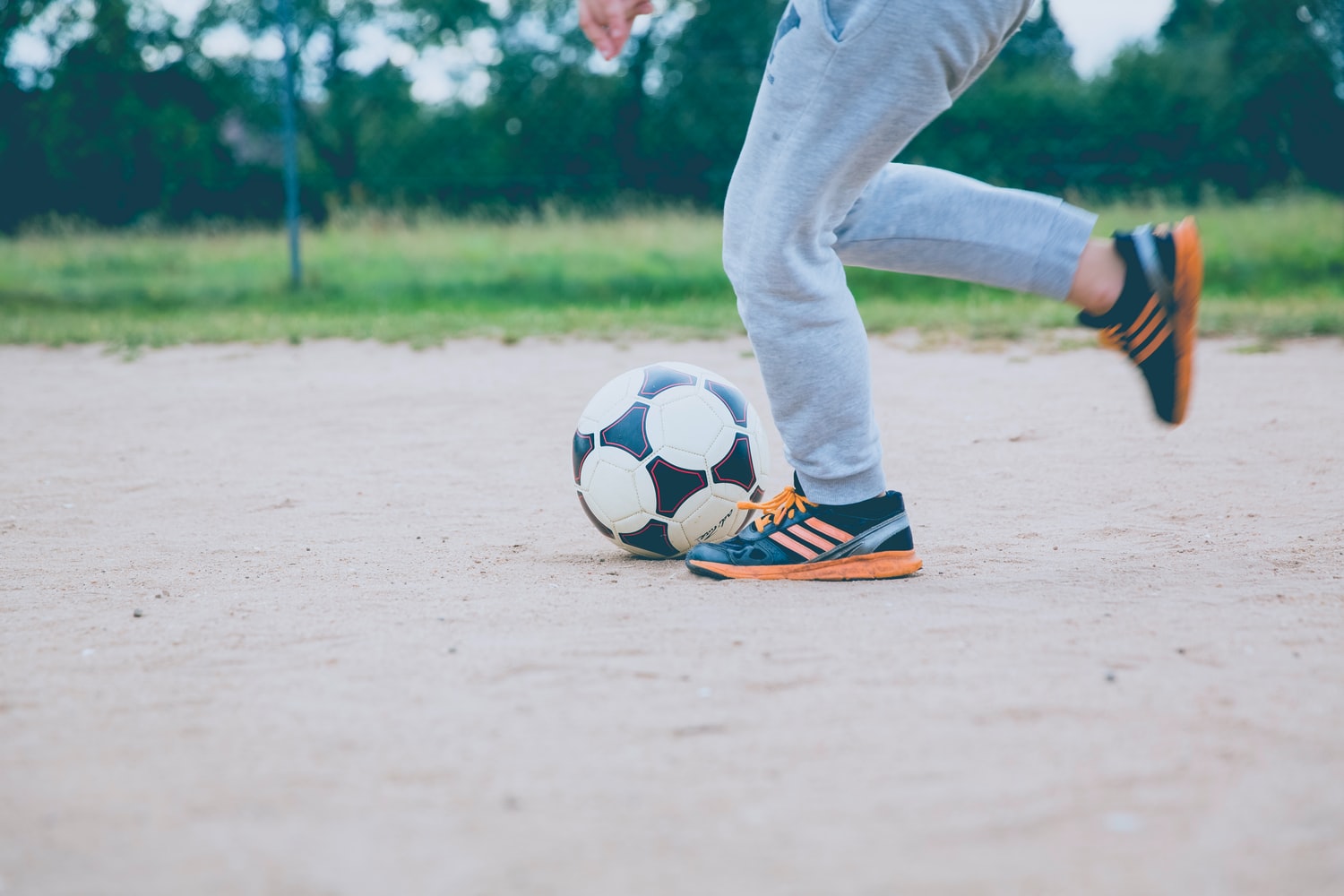 Person kicking soccer ball